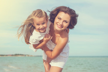 Fototapeta premium Mother and her daughter having fun on the beach
