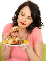 Young Woman Eating Cold Cooked Chicken Legs