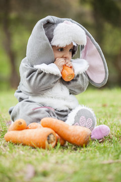 Peque&ntilde;a beb&eacute; de seis meses disfrazada de coneja comiendo zanahorias