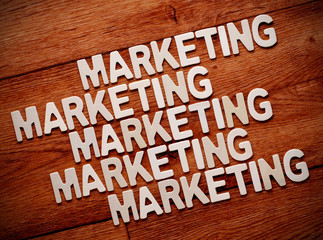 la parola marketing ripetuta sulla tavola di legno