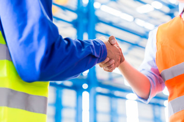 Worker and engineer handshake in factory