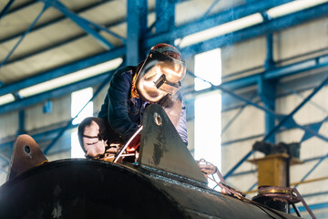Welder working in industrial factory