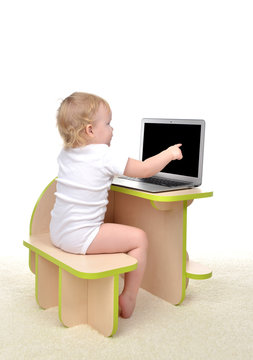 Сhild baby girl toddler sitting computer laptop pointing finget