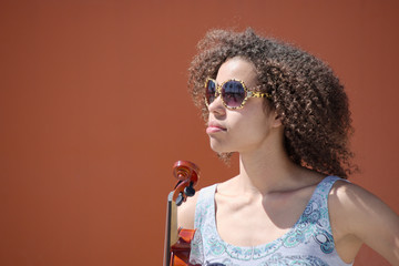 Female violinist with sunglasses staring into distance