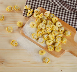 Uncooked italian Ravioli on  a wooden table.