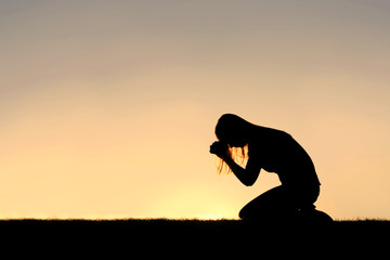 Obraz premium Christian Woman Sitting Down in Prayer Silhouette