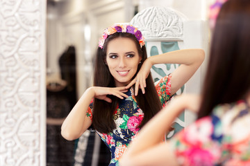 Beautiful Girl Looking in the Mirror and Trying on Floral Dress