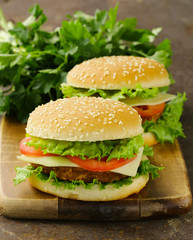 traditional cheeseburger with green lettuce and tomatoes - obrazy, fototapety, plakaty