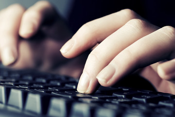 Female hands typing on computer keyboard