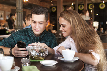 Young couple surfing the web looking at photos on mobile phone