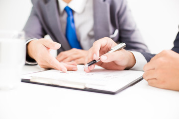 Two businessmen looking at report and having a discussion in off