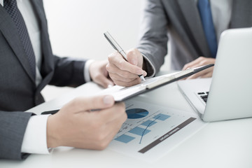 Two businessmen looking at report and having a discussion in off