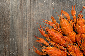 Plate of red crayfishes on old wooden table