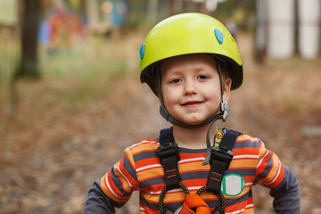 portrait brave little boy having fun at adventure park