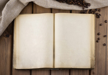 Fototapeta na wymiar Top view of blank old book with sackcloth and cofee beans 