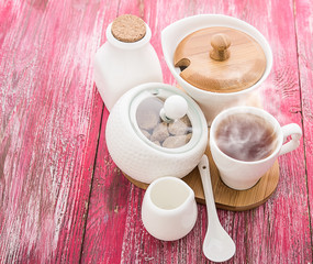 Tea cups with teapot on old wooden table