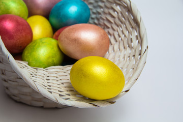 Easter colored eggs in a white basket