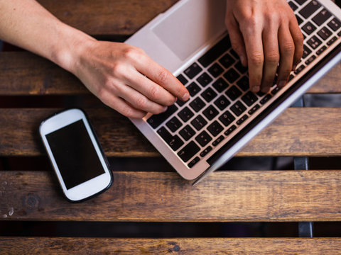 Close up on laptop, phone and hands