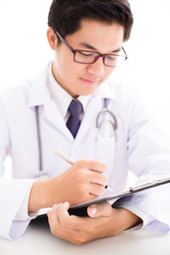 Close-up Of Male Doctor Filling The Medical Form