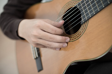 Fototapeta premium Practicing in playing guitar. Handsome young men playing guitar