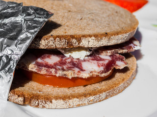 Sandwich with salami, cheese, and tomato