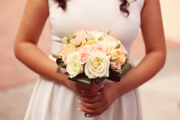 Obraz na płótnie Canvas Bride holding bouquet of roses