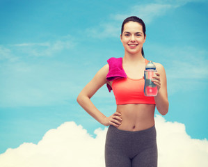 sporty woman with towel and water bottle