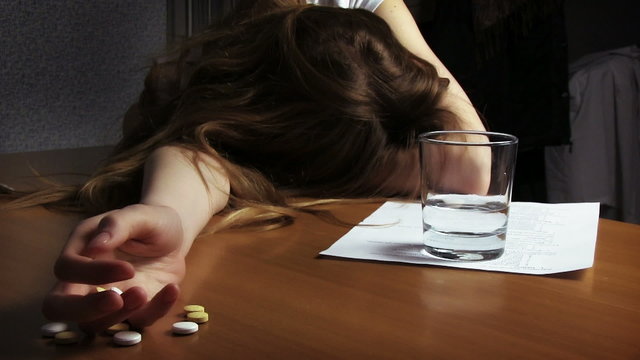 Woman suicide concept. Hand with pills on the table