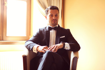 Elegant young fashion man in a hotel room