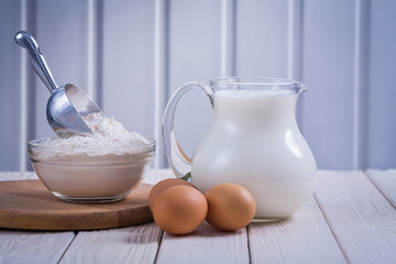 horizontal view eggs flour in transparent bowl pitcher with milk