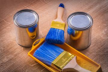 two paint cans brushes tray on wooden board construction concept