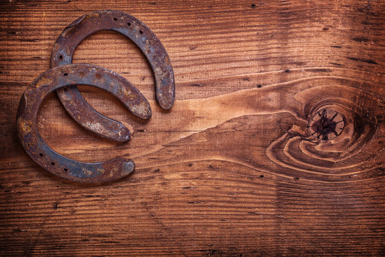 two horseshoe on vintage wooden board close up happy concept