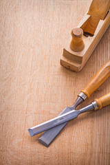 woodworkers plane and carpentry chisel on wooden board with orga