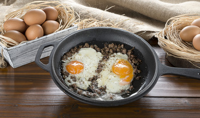 Braised beef with egg on iron cast pan.
