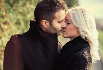 a pair of lovers kissing on a warm spring day in the park