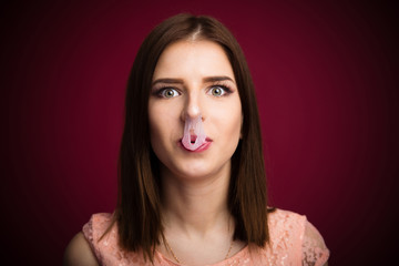 Woman blown up bubble gum on her nose and mouth
