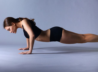 Portrait of young woman doing push ups