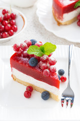 piece of cheesecake with berry jelly on a white plate, top view