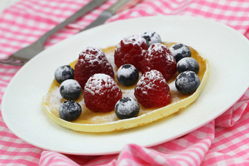 Pancake with blueberries and raspberries, closeup