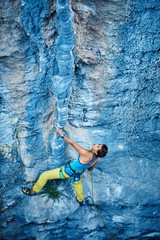 Rock climber climbing up a cliff