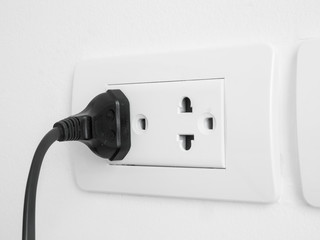 electronic power plug plugged in a wall socket