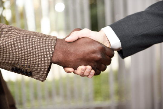 Black businessman shaking hands with a caucasian one