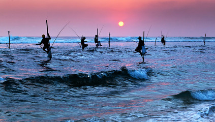 Silhouettes of the traditional stilt fishermen at the sunset nea