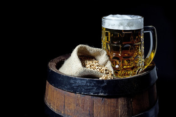Mug of Beer and Jute Bag with Wheat on Barrel Isolated on Black 