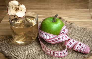 Apple juice with apples on wooden background
