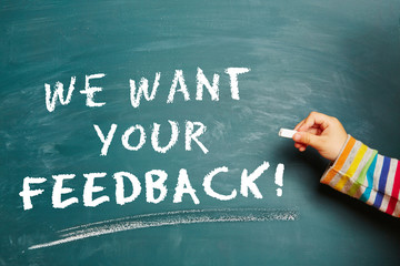 Hand schreibt We want your Feedback