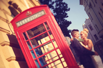 Bride and groom near phonebooth