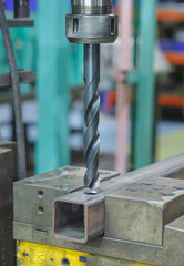 Industrial drill working in metal workshop