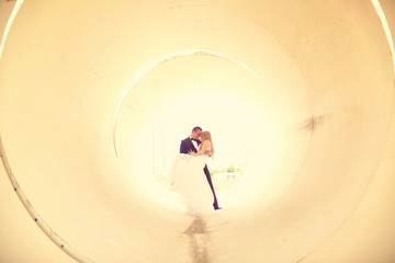 Bride and groom posing in a pipe