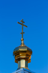 Fototapeta na wymiar Church dome with a cross against, blue sky